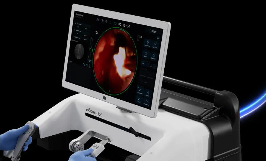 자메닉스 콘솔. 시술자가 양손으로 마스터 핸들을 잡고 있고 정면 화면에 내시경 영상이 떠 있다