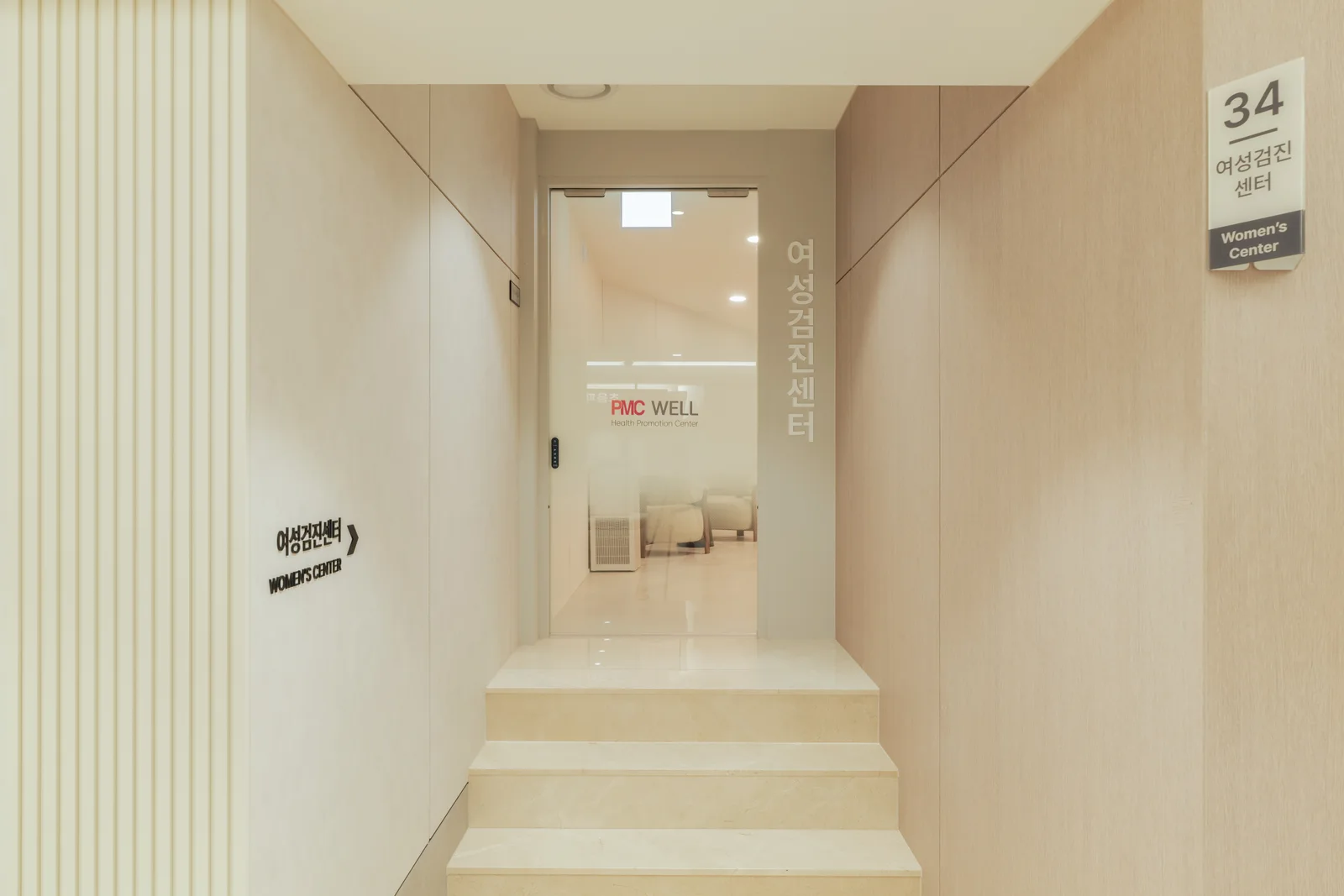 PMC 웰 센터 B1F 메인 통로에서 본 여성센터 입구 — '여성검진센터 34' 사인과 계단 위 유리문